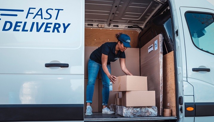 woman courier unloading parcels in a courier van